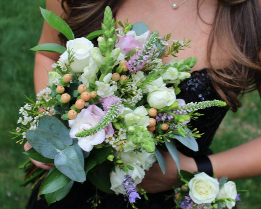 Bouquet of flowers held by a person against a blurred green background
