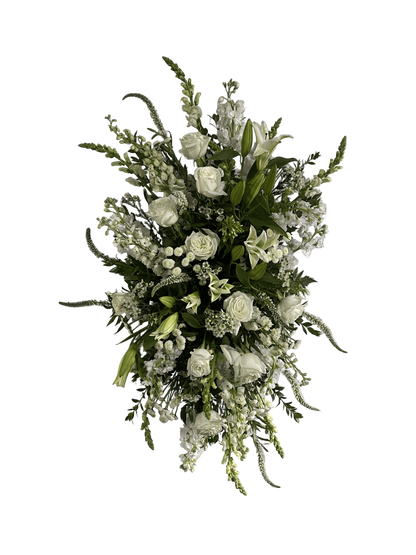 a white standing floral spray featuring roses, snapdragons, stock, and more