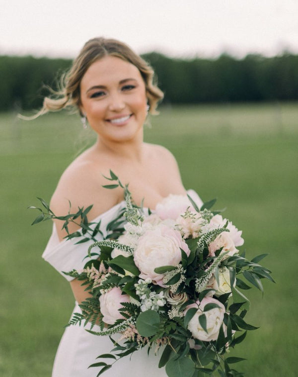 Woman holding a bouquet of flowers in a field