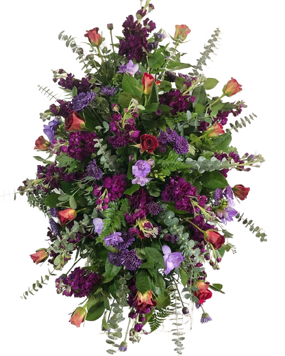 Colorful floral standing spray with purple stock, red roses, eucalyptus, and greenery with other flowers