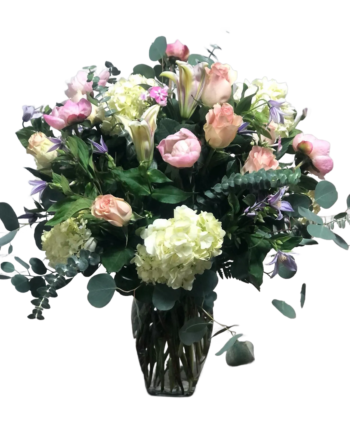 bouquet with pink roses, green hydrangea, white lilies, and purple clematis, in a clear vase 