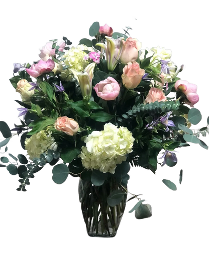 bouquet with pink roses, green hydrangea, white lilies, and purple clematis, in a clear vase 
