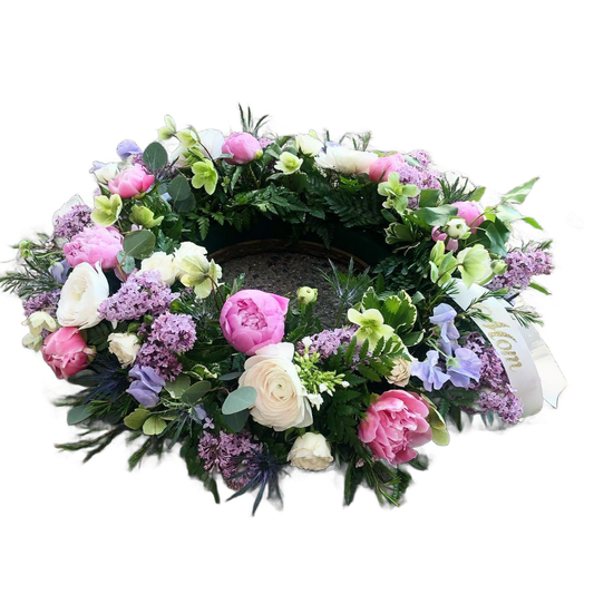 Floral wreath with pink peonies, white ranunculus, and purple lilac flowers 